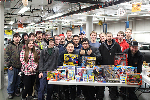 Dunwoody Automotive students standing next to toys being donated to Toys for Tots 