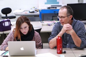 Graphic Design Instructor Tom Herold works with a student during class. 