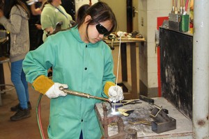 Photo of girl welding in welding lab.