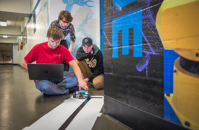 Photo of team 7 troubleshooting a prototype of their robot