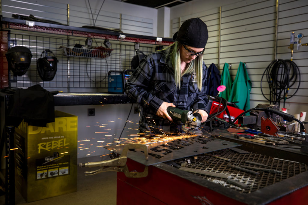 Alex Mars grinds a sign in her Lakeville shop.