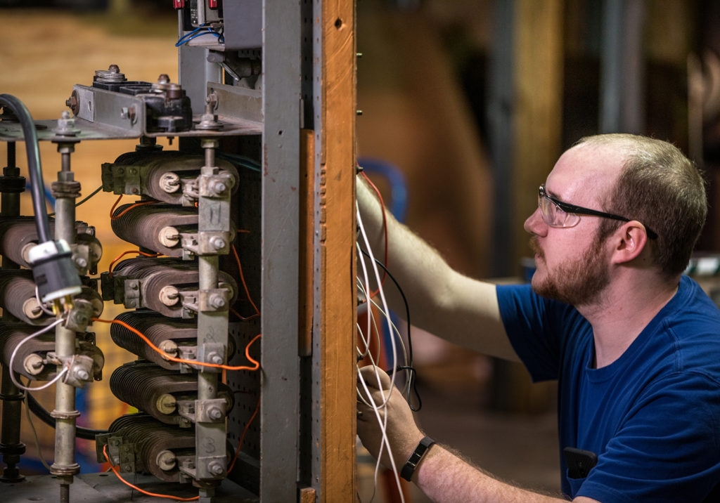 Cody Malinak tinkers with a variable speed Fwd / Rev drum controller to a wound rotor motor. Historically these are very early versions of what we now call a variable frequency drive.