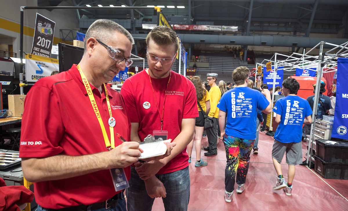 E.J. Daigle and Donald Posterick judge robot entries at First Robotics held at the University of Minnesota May 18, 2019. Dunwoody awards a trophy and a money to winners.
