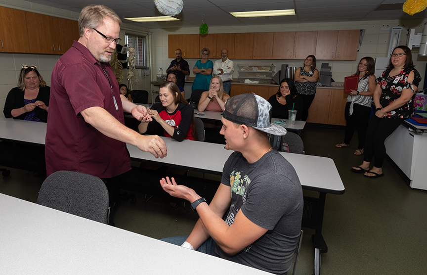 David Blake, Program Manager for Radiologic Technology, hands Brayden Snow his pin during the Rad Tech Pinning Ceremony.