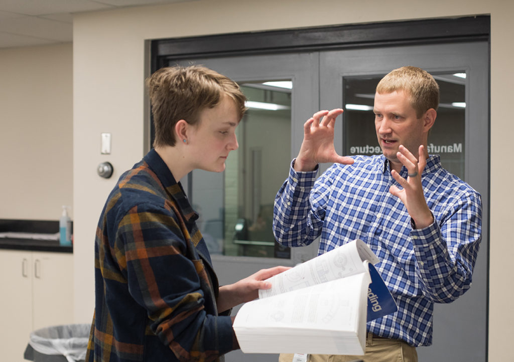 Andrew Hoitink explains a classroom exercise to a student