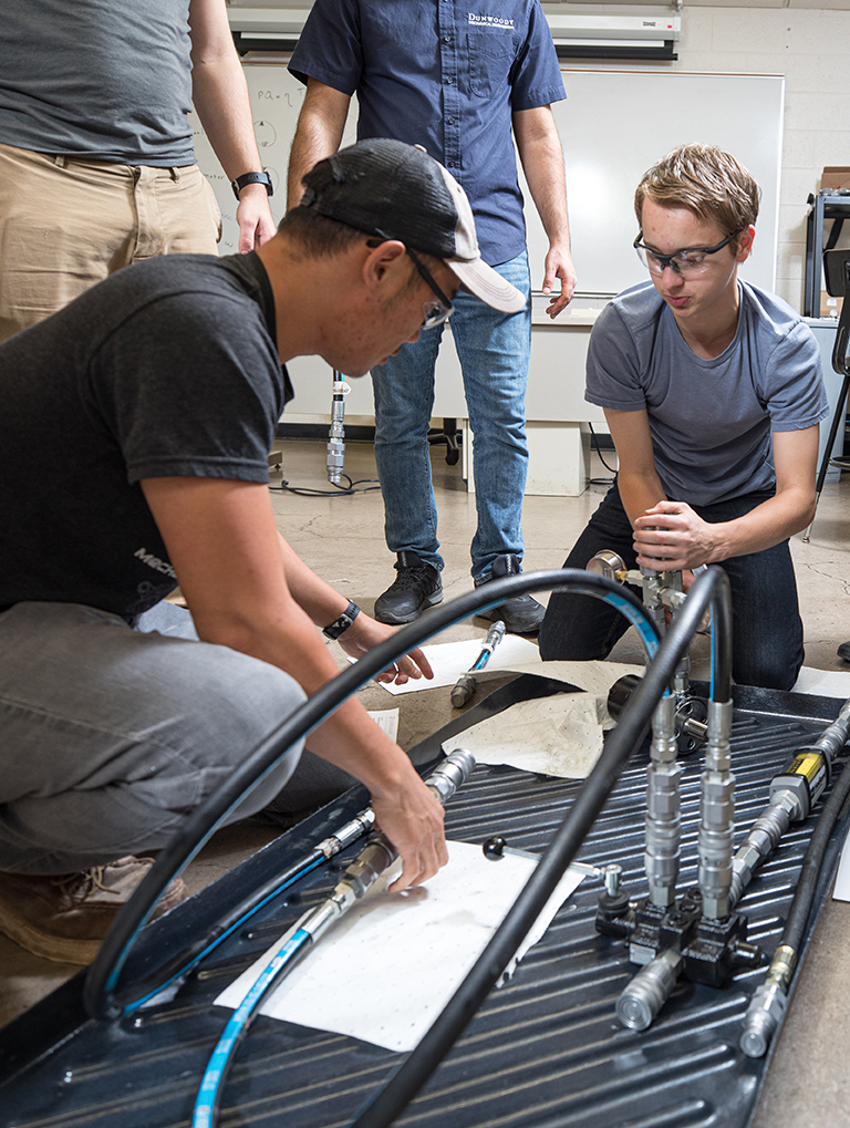 Benjamin Larsen works with other students in Mechanical Engineering lab.