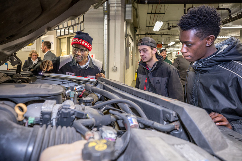 Students looking over engine