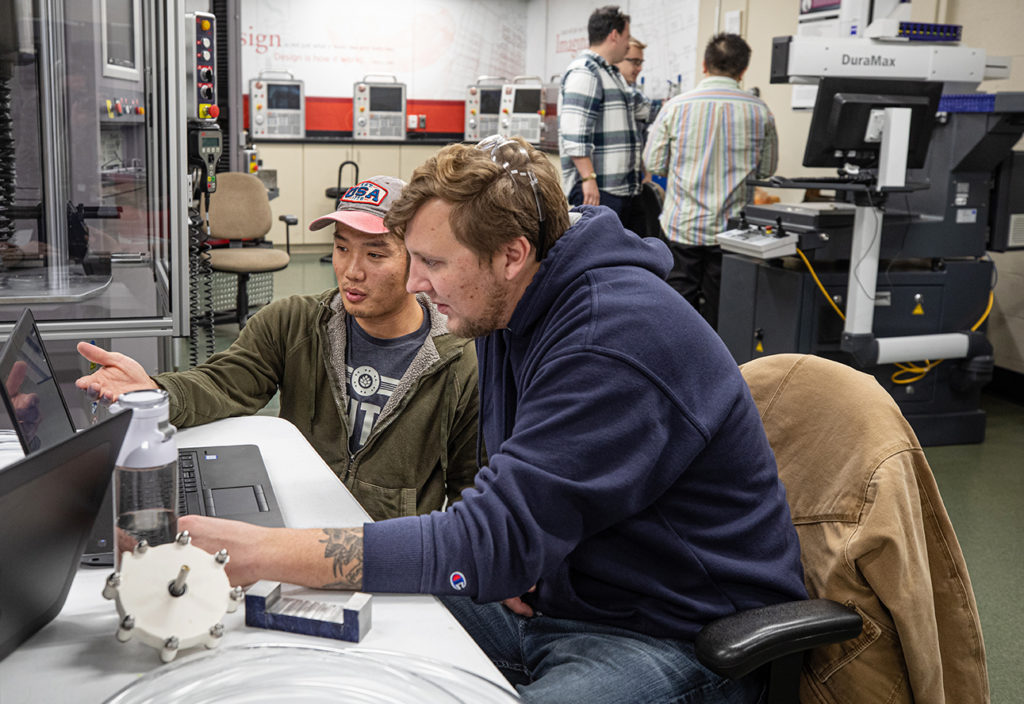 Mechanical Engineering students Tommy Dao, left, works with fellow student Dan Hurd in the Metrology lab on their senior capstone project.