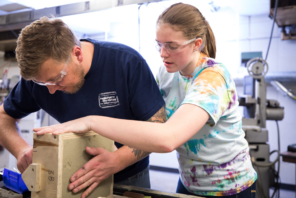 Mechanical Engineering students Dan Hurd, left, and Angela Freeland, right, sandcast a mold to make aluminum wrenches in the Foundry.