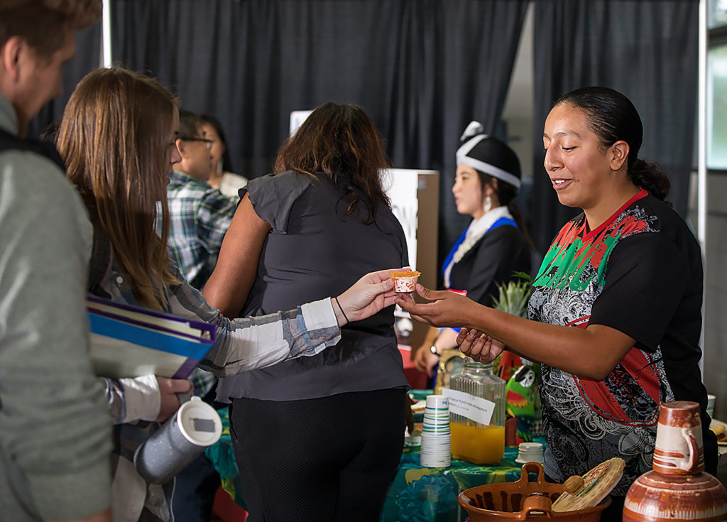 Liz Rivas,right, shares food she made with other students during the Festival of Cultures.