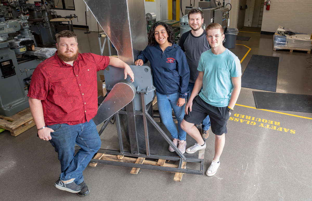 Thomas Oldenburg, Elizabeth Rivas, Roy Heggernes and Justin Grant pose with the machine they created as their Capstone for Mechanical Engineering