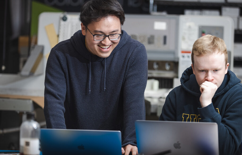 Yekong Thao, left, work with another student in the Graphic Design lab.