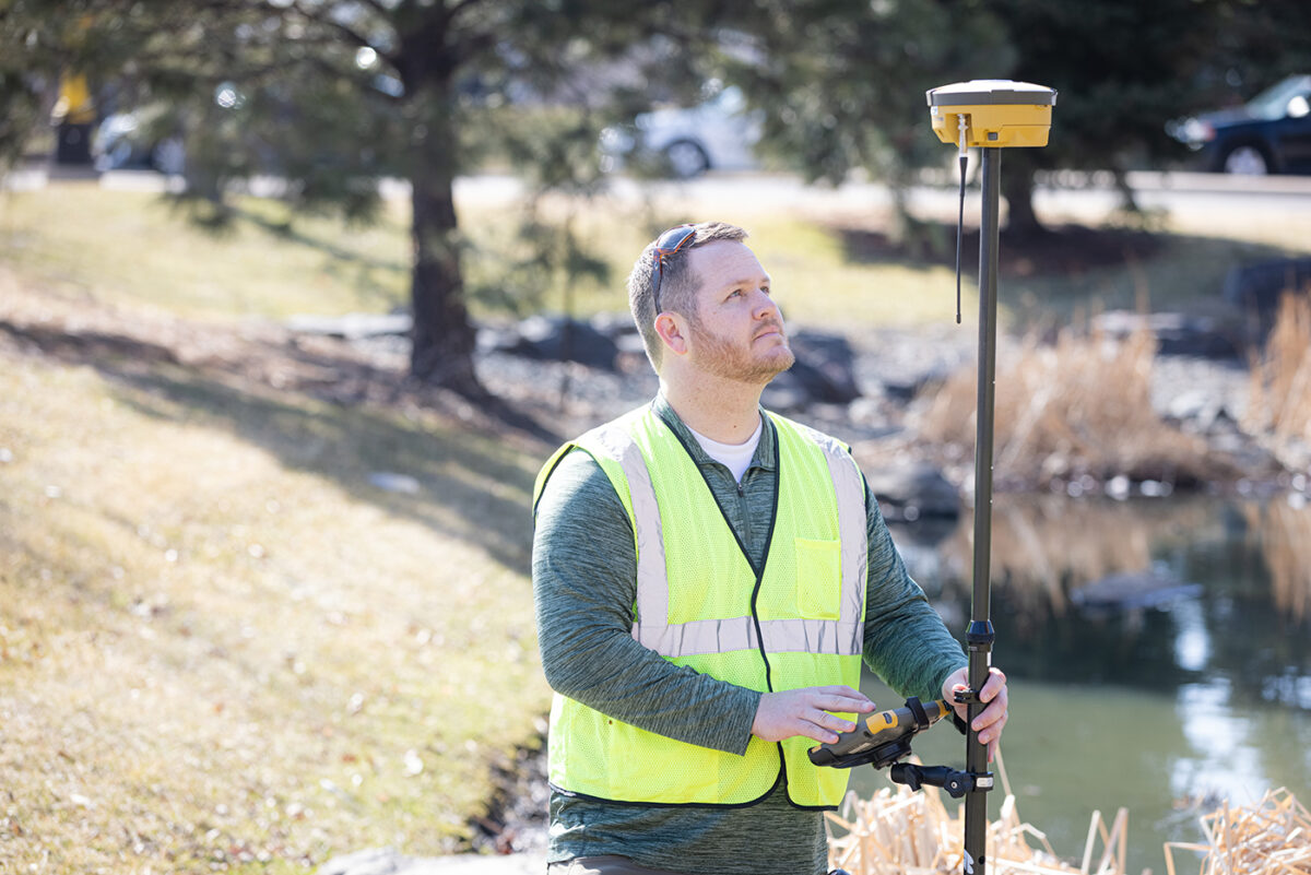 Kyle Brockett uses surveying equipment at Dunwoody