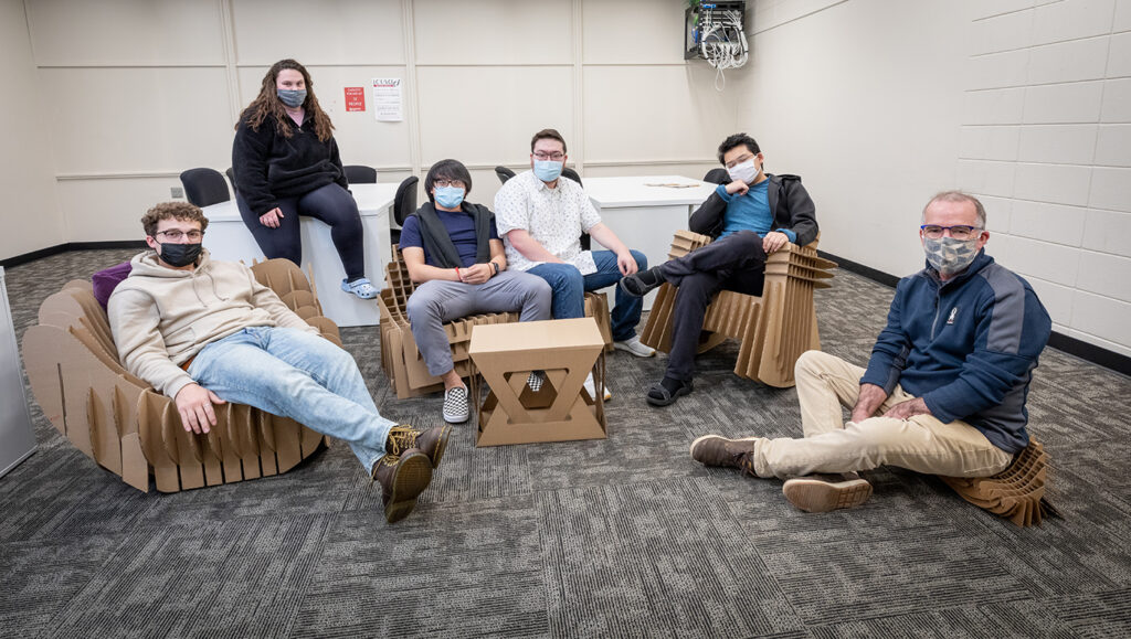 Yengkong Thao, third from left, sits on furniture he and his classmates created out of corrugated material. 