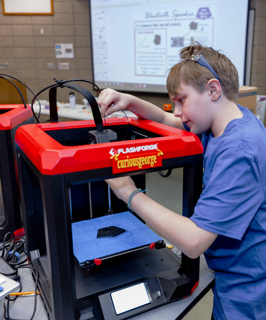Student changes out filament for his 3D printer. 