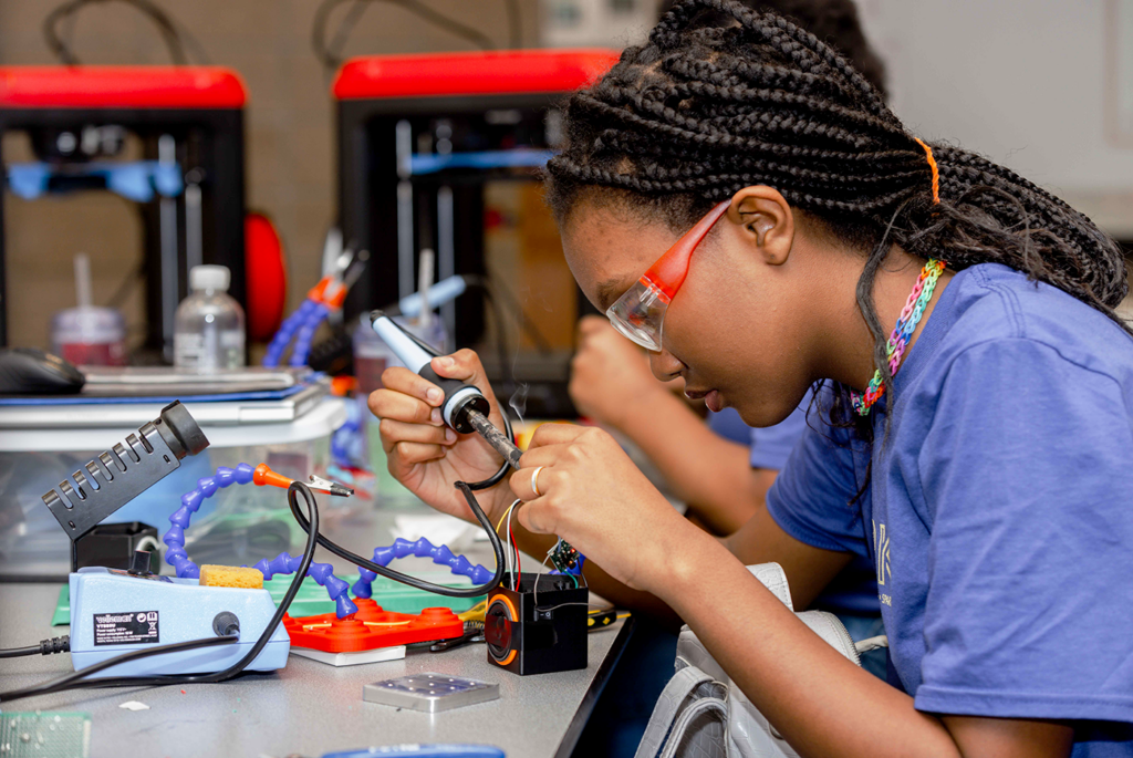 A student wires a bluetooth speaker. 