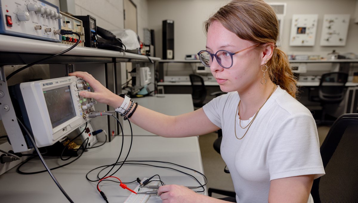 photo of Laurengail Lorenz working on electrical equipment in lab.