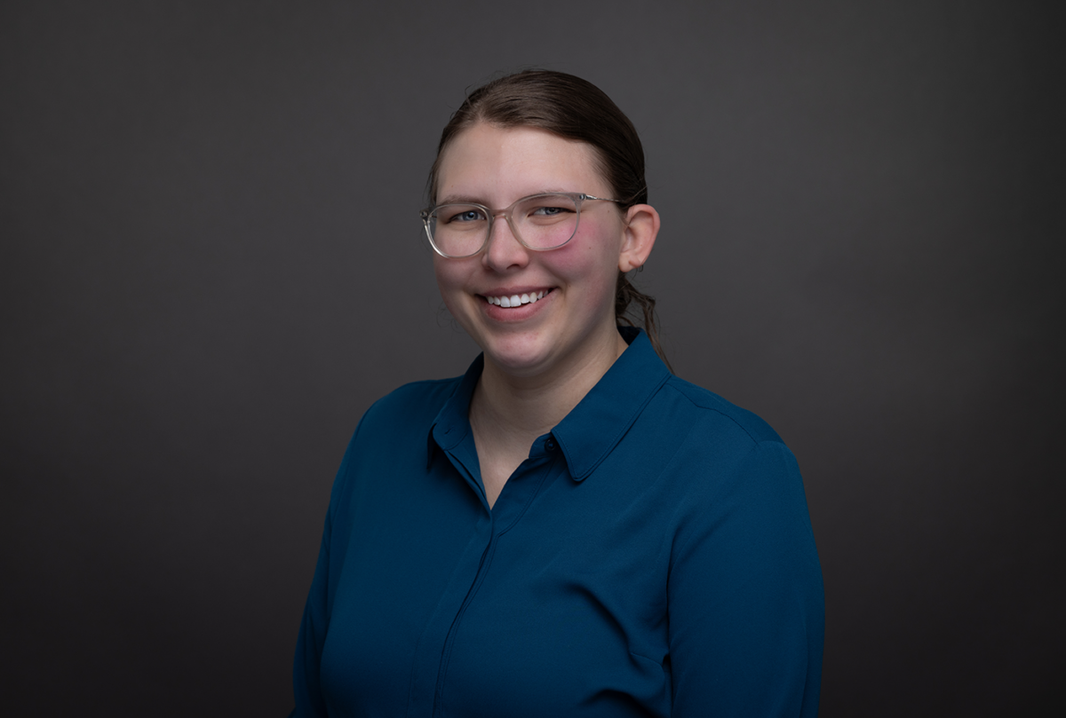 Portrait of Ashely Sather, smiling, wearing a teal blouse.