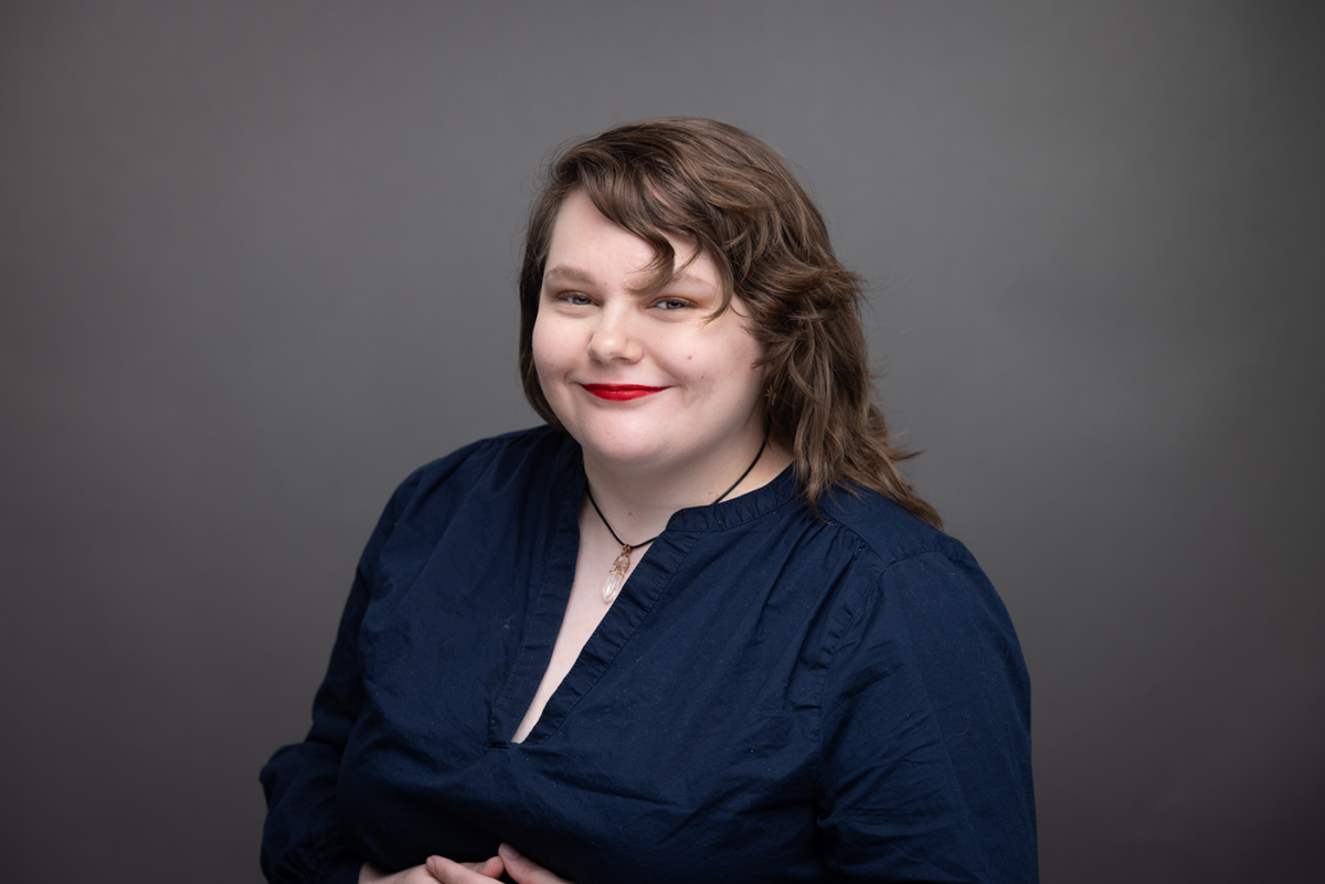 Portrait of Mina Hunter-Baltes smiling, wearing a blue shirt.