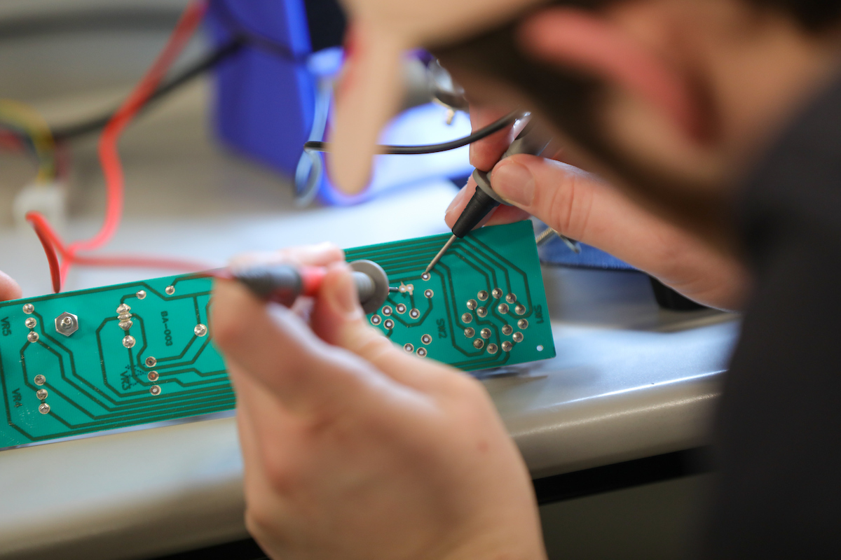 Student soldering in an electronics lab.