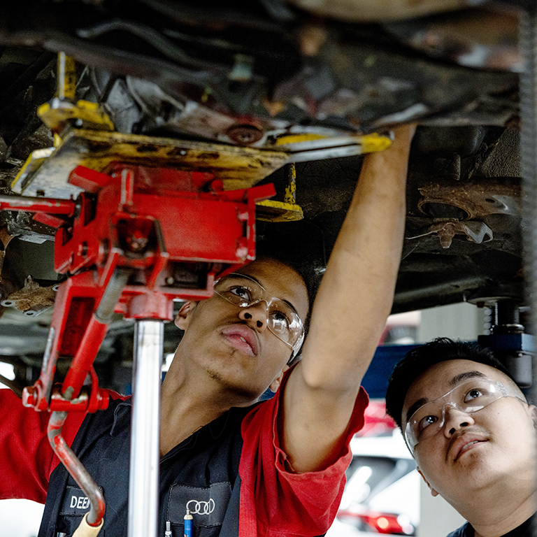 Students in the Automotive program install a transmission in a vehicle.