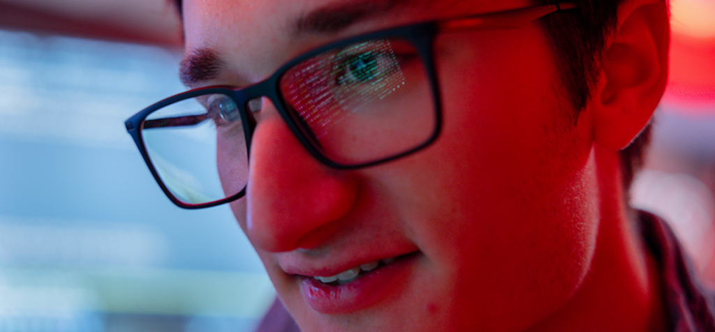 An image showing lines of code reflected in a person's glasses in multi-color scripting, important for any web programmer or database programmer.