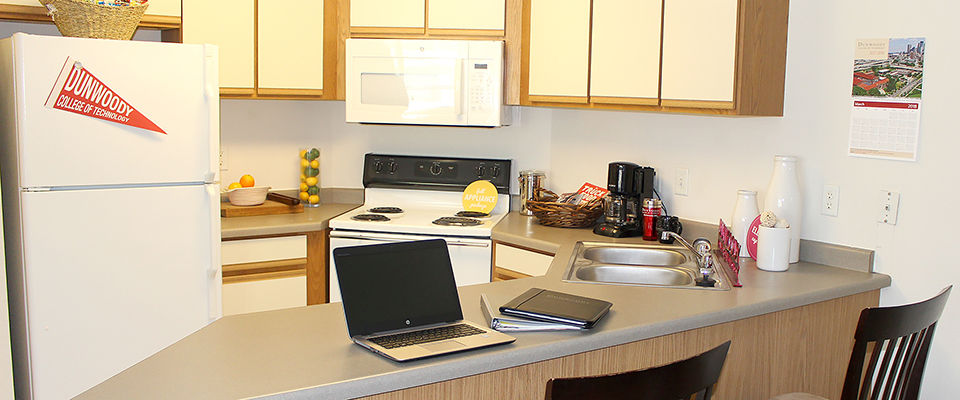 Kitchen area showing counter space, fridge, range with oven, microwave, and cupboards and drawers