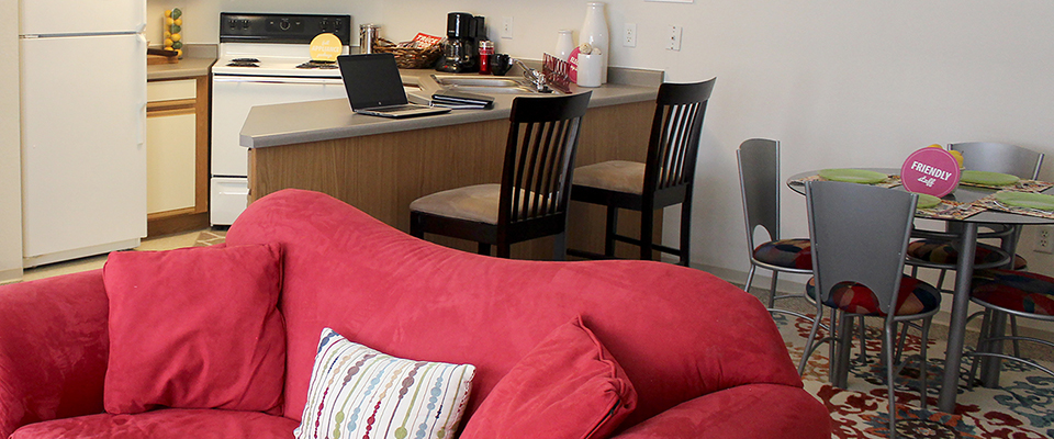 Dining area with a table and four chairs plus a breakfast bar with two stools