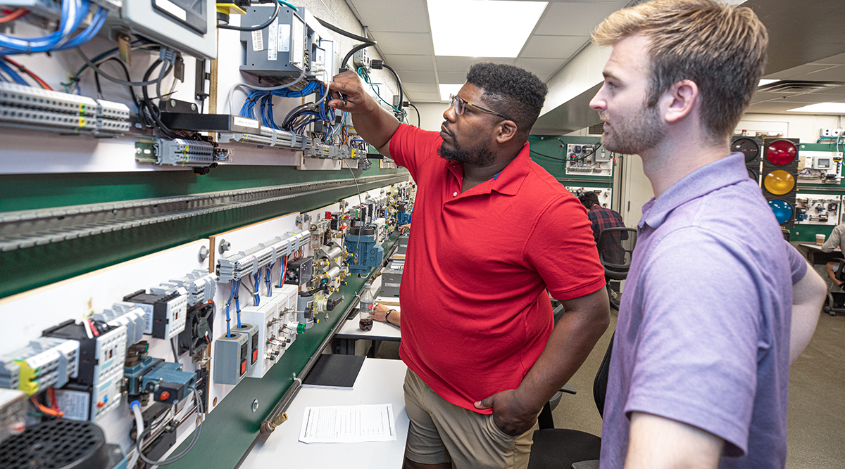Photo of two students working in the industrial controls lab