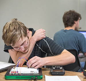 An electrical engineering student working on a breadboard