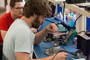 Students working on a breadboard in the electronics lab