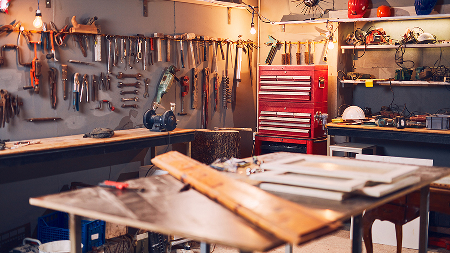 Photo of a workshop filled with a variety of different tools and a large work table